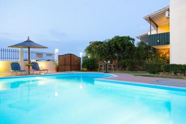 Grande piscina all'aperto di Villa Altina, perfettamente integrata nel paesaggio circostante, ideale per momenti di relax e convivialità.