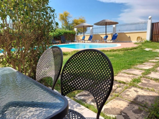 Tavolo esterno immerso nel giardino di Villa Altina, ideale per pranzi e cene all'aperto circondati dalla natura.