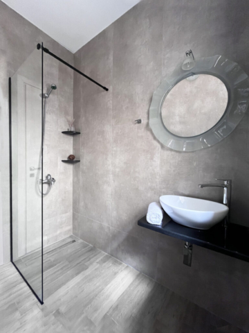 Bagno moderno con doccia situato al pianterreno di Villa White, arredato con eleganza e funzionalità.