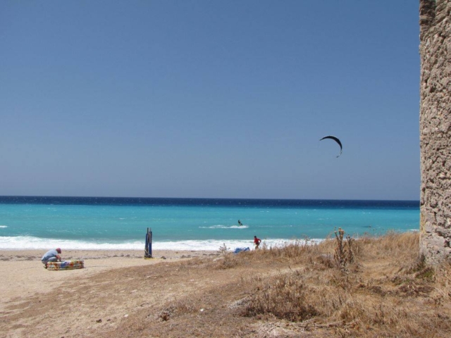 Panorama che si apre dietro un mulino sulla spiaggia di Agios Ioannis, con il mare e il paesaggio circostante di Lefkada.